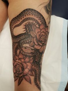 a woman's leg with a snake and flowers on it