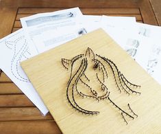 a wooden cutting board with a horse drawn on it's side and some envelopes next to it