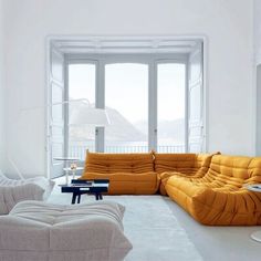 a living room filled with lots of white furniture