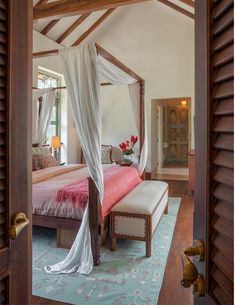 a bedroom with a canopy bed and white drapes