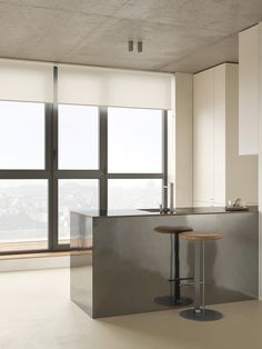 an empty kitchen with two stools in front of the counter and large window overlooking city