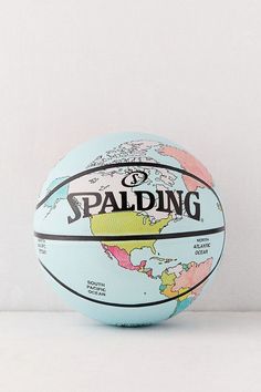 a basketball sitting on top of a white table next to a wall with the words spalding written on it