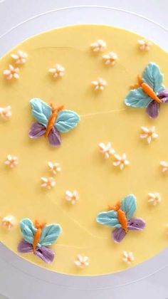 a cake decorated with flowers and butterflies on a plate