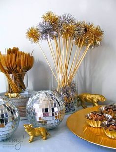 disco ball decorations on a table with gold and silver plates