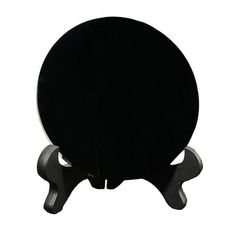 a black table top with two legs and a round base on the bottom, against a white background