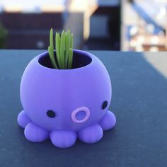 an octopus planter is sitting on a table with grass in it's mouth