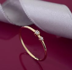 Dieser zarte Ring ist aus 585er Gold gefertigt und mit zwei winzigen Zirkonia-Steinen in verschiedenen Größen verziert. Dank seines minimalistischen Designs eignet es sich perfekt für den Lagenlook oder allein als elegantes Statement-Piece getragen. Perfekt für Frauen, die schlichten Schmuck bevorzugen. RINGDETAILS ♥ Gold Karat: 14 Karat solides Gold ♥ Edelstein: Cubic Zirkonia ♥ Der Ring wird in einer außergewöhnlichen Geschenkbox geliefert. ♥ Du kannst zwischen 585er Weißgold, 585er Roségold u Stone Stacking, Simple Jewellery, Gold Promise Ring, Conversion Table, Jewellery Ring, Gold Promise Rings, Ring Minimalist, Ring Dainty, Delicate Rings