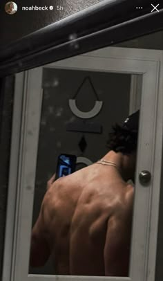 a shirtless man taking a selfie in the mirror