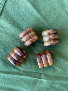 four pieces of wood sitting on top of a green cloth next to each other with holes in the middle