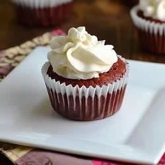 cupcakes with white frosting sitting on a plate