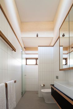 a bathroom with a toilet, sink and mirror in it's center wall is shown