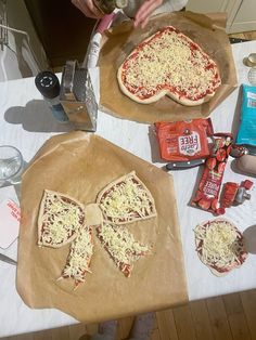 two uncooked pizzas sitting on top of a table