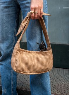 Just the essentials. This is a baguette-style mini bag with an oversized adjustable tie at the shoulder. Made from a 1960s tweed to spruce up any boring outfit. Small size that still manages to fit a lot (8.5x6x2 inches). Snap closure and inside zip pocket for important things. Style handheld or throw on the shoulder. Our vintage-fabric-womenswear is made of vintage fabric remnants dating 1930-1989, meaning each piece has zero impact on the environment and is what we like to call few-of-a-kind™. White Houndstooth, West Village, Fabric Remnants, Tweed Fabric, Vintage Textiles, Upcycled Vintage, Vintage Fabric, Snap Closure, Bow Tie