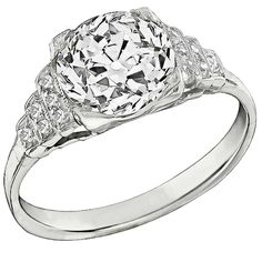 a white gold ring with an oval cut diamond in the center and two smaller round diamonds on each side