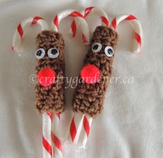 two candy canes decorated to look like reindeer noses