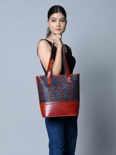 Introducing the handcrafted leather structured tote, where traditional craft meets modern design. The upper portion features authentic Ajrakh printed fabric stitched on durable leather, infusing a traditional and ethnic feel. With sturdy leather handles and a spacious central compartment, it accommodates books, journals, diaries, and laptops with ease. Crafted from naturally tanned buffalo leather, this tote embraces a chemical-free approach, allowing you to carry a piece of cultural heritage wi Traditional Leather Tote Shoulder Bag, Traditional Daily Shoulder Bag With Leather Lining, Traditional Leather Lined Shoulder Bag For Daily Use, Traditional Bags With Leather Lining For Everyday Use, Traditional Bag With Leather Lining For Everyday Use, Traditional Leather Tote Bag, Traditional Leather Shoulder Bag For Everyday, Traditional Leather Shoulder Bag, Books Journal