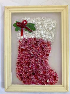 a christmas stocking made out of red and white beads with a green leaf on top