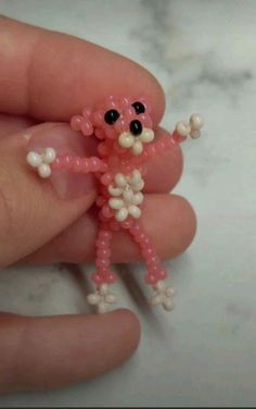 someone is holding a tiny beaded toy in their hand