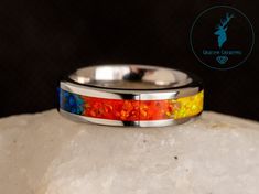 These Rings Are Hand-Made To Order! Add a unique touch to your style with this handmade AroAce Pride ring. It features a striking combination of a band in your choice of material and an inlay of lab-grown opals in the colours of the AroAce pride sunset flag, with complimenting UV glow pigment powder. Choose from 6 ring materials; Black Zirconium, White Zirconium, Stainless Steel, Sterling Silver, Titanium, or Tungsten Choose from 3.2mm/4mm, 6mm, or 8mm band width options. Please note that 8mm ba Sunset Flag, Pride Wedding, Asexual Pride, Pigment Powder, Gemstone Jewellery, Engraved Rings, Opal Gemstone, Handmade Ring, Lab Grown