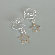 Star charm dangler, open ended sterling silver ear cuff. Dimensions: 6 x 8 mm Star: 8 x 8 Weight: .90gm Price listed is for ONE PIECE These are made of 925 hypoallergenic sterling silver. pieces come with a 925 stamp. Can be packaged in a gift box. I can include a personal message from you if needed You are welcome to contact me at... bhavnakwintra1956@gmail.com For more beautiful pieces from my shop, please browse 👇 TOE RINGS: https://www.etsy.com/your/shops/TheSilverGame/tools/listings/sectio Wrap Earrings, Silver Ear Cuff, Open Ended, Unisex Jewelry, Silver Pieces, Star Charms, Toe Rings, Personal Message, Ear Piercings