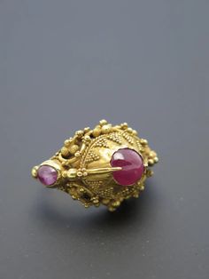 For Sale on 1stDibs - Finely worked in high karat gold (22k+) and featuring three rough cut ruby cabochons ranging form light pink to purplish pink, typical of rubies from Indonesia. Traditional Ruby Ring In Yellow Gold, Gold Ruby Rings With Intricate Design, Ceremonial Yellow Gold Ruby Ring With Intricate Design, Fine Jewelry Gold Ruby Ring With Intricate Design, Ceremonial Yellow Gold Ruby Ring, Gold Ruby Ring With Intricate Design, Traditional Yellow Gold Ruby Ring With Gemstone, Traditional Oval Ruby Ring, Traditional Ruby Rings For Ceremonial Occasions