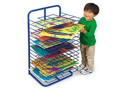 a young boy standing next to a rack with books