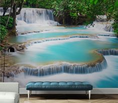 a room with a wall mural that has waterfalls and blue water in the middle