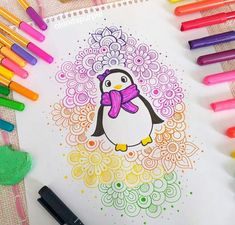 a penguin with a scarf on it's head surrounded by crayons and markers