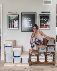 a woman sitting on top of a wooden box next to some baskets and containers in front of her