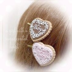 two heart shaped hair pins on top of a head