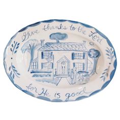 a blue and white plate with an image of a house that says, give thanks to the lord