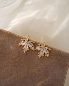 Discover a new level of elegance with our Ella Ear Jackets! Made with sparkling cubic zirconia and designed in the shape of delicate leaves, these earrings will enhance your natural beauty and elevate any outfit. Treat yourself or someone special to these stunning little luxuries! EARRINGS FEATURE Material: Brass, White Cubic Zirconia Finish: 16K gold plating Feminine Gold Petal Earrings, Elegant Leaf-shaped Formal Earrings, Elegant Leaf-shaped Earrings For Formal Occasions, Elegant White Leaf-shaped Earrings, Nature-inspired Drop Flower Earrings For Pierced Ears, Elegant Leaf-shaped Earrings, Nature-inspired Gold Flower Earrings, Gold Leaf Nature-inspired Earrings, Gold Ear Jacket