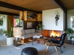 a living room filled with furniture and a fire place in the middle of the room