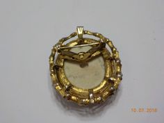 "Vintage hand painted ceramic brooch/pendant. Attach a chain & wear as a pendant necklace. Gorgeous ornate gold tone frame. Brooch is 1 1/2\" x 2\" with gorgeous flowers. Standard working spring fastener. Excellent condition. Signed by the artist..illegible." Gold Cameo Medallion Brooches, Gold Cameo Medallion Brooch, Gold Enamel Costume Jewelry Brooches, Ceramic Brooch, Sweater Clip, Heart Brooch, Gorgeous Flowers, Purple Rhinestone, Hand Painted Ceramic