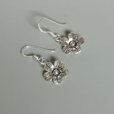 A PAIR of sterling silver flower ear danglers. Dimensions: 10 x 10 mm Drop length:22 mm Weight: 1.42 gm Price listed is for a PAIR of hoops. These earrings are made of 925 hypoallergenic sterling silver and comes with a 925 stamp. Can be packaged in a gift box. I can include a personal message from you if needed You are welcome to contact me at... bhavnakwintra1956@gmail.com For more beautiful pieces from my shop, please browse 👇 TOE RINGS: https://www.etsy.com/your/shops/TheSilverGame/tools/li Sterling Silver Flower Charm Earrings For Anniversary, Delicate Silver Earrings With Flower Charm, Sterling Silver Flower Charm Earrings, Delicate Silver Flower Earrings For Anniversary, Delicate Silver Flower Earrings Nickel-free, Delicate Silver Flower Earrings Nickel Free, Delicate Silver Nickel-free Flower Earrings, Silver Delicate Nickel-free Flower Earrings, Sterling Silver Flower-shaped Earrings