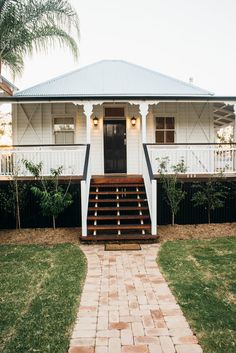 a white house with steps leading to the front door