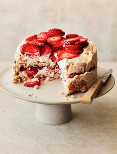 a cake with strawberries on top is cut in half and ready to be eaten