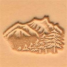 a stamp with trees and mountains in the background on a piece of paper that is carved into wood