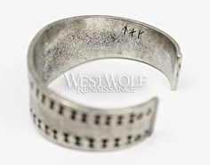 This beautiful Viking bracelet is historically accurate and modeled after a silver Viking bracelet found in the Curedale hoard at Lancashire, England in 1840. This type of stamped design was common in Viking culture, and solid silver bracelets such as this would have been used both as bullion and as jewelry. This particular bracelet we offer has been handmade of finely polished silver pewter and recreated from the archaeological find in every detail. The metal of this bracelet is completely safe Antique Silver Medieval Jewelry With Oxidized Finish, Medieval Jewelry In Antique Silver With Oxidized Finish, Hand Forged Medieval Silver Jewelry, Hand Forged Silver Medieval Jewelry, Medieval Style Engraved Antique Silver Jewelry, Medieval Style Adjustable Engraved Jewelry, Medieval Engraved Bracelet Jewelry, Hand Forged Silver Viking Jewelry, Viking Style Silver Bangle Bracelet