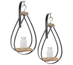 pair of metal and wood tear shaped candle holders with glass bottles hanging from the sides