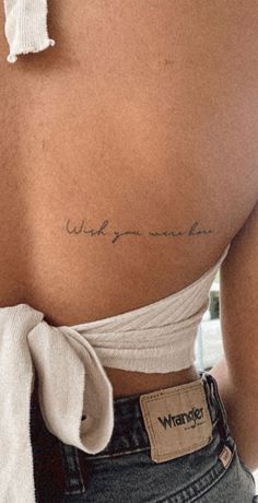 the back of a woman's stomach with writing on her left shoulder and right arm