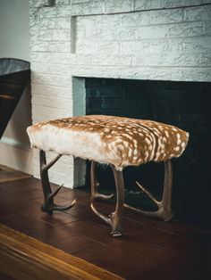 a deer bench sitting in front of a fireplace