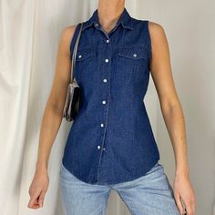 Vintage 80s/90s sleeveless denim shirt. Dark blue vintage wash denim sleeveless shirt with pearl snap buttons. Western style. 100% cotton. Perfect for layering. Size S on label, best fit up to a size 6-10. Seen on a size 6/8 (5ft9) Great vintage condition. Measurements: Chest: 36 inches Length 26 inches Washed Blue Button-up Denim Vest For Summer, Casual Denim Sleeveless Vest With Snap Buttons, Casual Indigo Cotton Denim Vest, Classic Denim Blue Cotton Denim Vest, Classic Denim Blue Cotton Vest, Dark Wash Cotton Denim Vest With Button Closure, Sleeveless Cotton Denim Jacket With Button Closure, Washed Cotton Sleeveless Denim Vest, Sleeveless Washed Dark Wash Denim Top