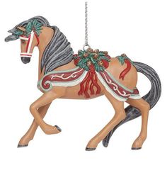 a christmas ornament with a horse on it's back and red accents