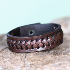 This bold bracelet by Tomomi showcases braided textures. Featuring interlacing created by hand, the wristband is handcrafted of brown leather. Brown Leather Braided Bracelet As Gift, Brown Leather Strap Braided Bracelet Gift, Adjustable Brown Leather Braided Bracelet, Adjustable Brown Leather Bracelet With Waxed Finish, Brown Braided Leather Bracelets, Brown Leather Braided Bracelet, Brown Leather Strap Bracelet, Adjustable Brown Bracelet With Waxed Finish, Adjustable Brown Leather Bracelet With Wrist Strap