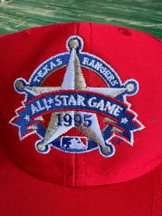 Add this limited edition 1995 Texas Rangers All Star Game SnapBack Hat to your collection. Show off your love for the team with the vibrant red, white, and blue embroidered graphic. A must-have for any true fan. Don't miss out on this authentic piece of baseball history. Like new condition This item is preloved Throwback Snapback Hat For Baseball Season With Embroidered Logo, Baseball Season Cap With Logo Patch For Fans, Throwback Snapback Hat For Baseball Season, Snapback Baseball Cap For Fan Events, Baseball Season Fan Merchandise Cap With Logo Patch, Throwback Baseball Cap With Embroidered Logo For Game Day, American Snapback Baseball Cap For Baseball Season, Vintage Snapback Hat With Embroidered Logo For Baseball Season, American Style Snapback Baseball Cap