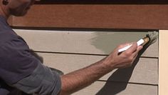 a man painting the side of a house