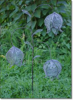 three metal wire flowers in the grass