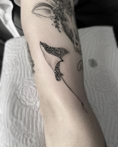 a woman's arm with a tattoo on it that has a whale tail and flowers