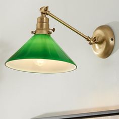 a green light hanging from the side of a wall next to a white wall and door